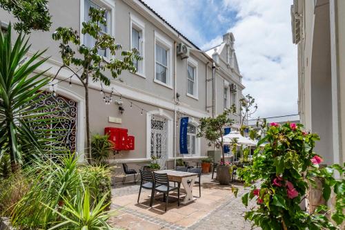 a courtyard of a building with a table and chairs at The Willets Boutique Hotel in Simon's Town in Simonʼs Town