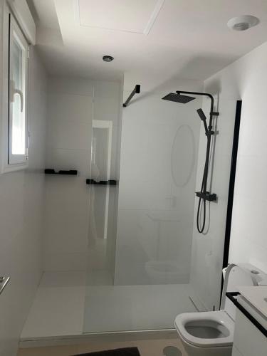 a white bathroom with a shower and a toilet at Habitación En Casa de Familia Room in family home Solamente para personas tranquilas Only quiet people in Marbella
