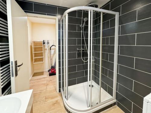 La salle de bains est pourvue d'une douche et de carrelage noir. dans l'établissement Eglise 2 - Maisonnette pour 6 à Disneyland Paris, à Coutevroult