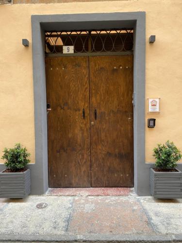 una puerta marrón con dos macetas delante de ella en Queen rooom ModeRna - Relax e privacy a 2 passi dal Duomo, en Módena