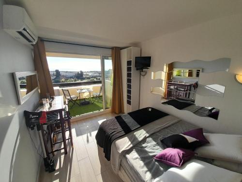 une petite chambre avec un lit et un balcon dans l'établissement Studio Village Naturiste Lollipop, au Cap d'Agde