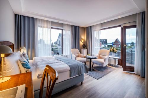 a hotel room with a bed and a table and chairs at Büngers Apartment-Hotel mit Sommerstrandkorb & Gartensauna in Strande