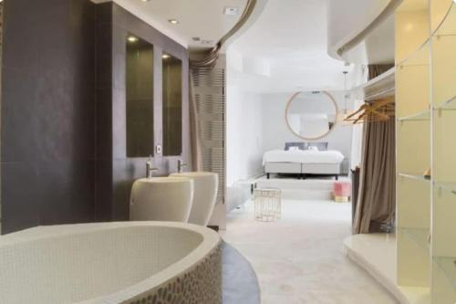 une salle de bain avec une baignoire, un lavabo et un miroir dans l'établissement Magnifique appartement parisien - Marais, à Paris