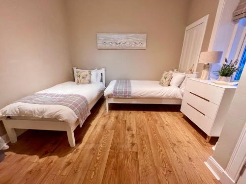 a bedroom with two beds and a dresser at Sea Sound in Cellardyke