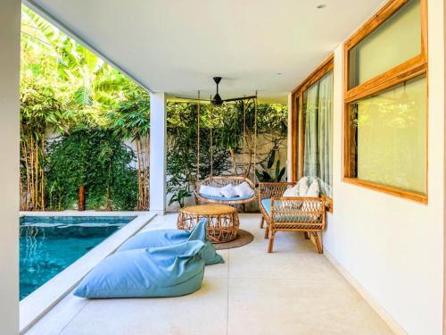 a patio with a swing and a swimming pool at Marlaca Villas Lombok in Kuta Lombok