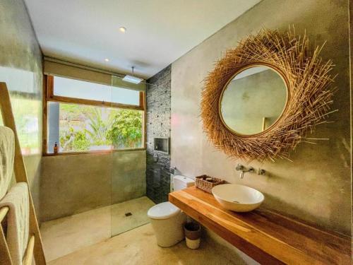 a bathroom with a sink and a mirror on the wall at Marlaca Villas Lombok in Kuta Lombok