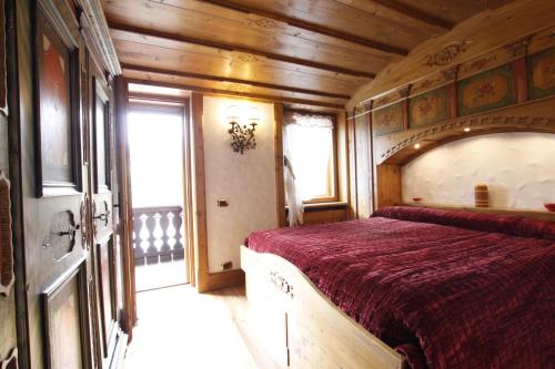 a bedroom with a large bed in a room with wooden walls at Chalet Ampezzano di Marisa in Cortina dʼAmpezzo