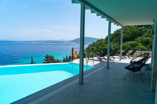 a swimming pool with a view of the water at Kaminia Blue Villas in Tsoukaladhes