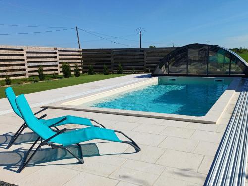 une chaise bleue assise à côté d'une piscine dans l'établissement Gîtes Les 2 Fontaines, à Marans