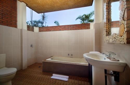 a bathroom with a sink and a tub and a toilet at Kanaka Villas by Prabha in Tampaksiring