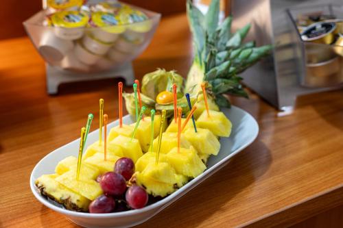 um prato de comida com fruta sobre uma mesa em Montana Trend Hotel Lehrte em Lehrte