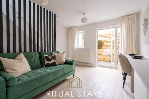 a living room with a green couch and a table at The Bracken's by Ritual Stays in Hemel Hempstead