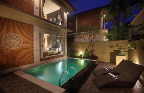 a swimming pool in the backyard of a house at night at Kanaka Villas by Prabha in Tampaksiring