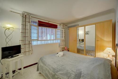 une chambre avec un lit, une télévision et une fenêtre dans l'établissement Spacieux 2 Pièces Vue panoramique sur Port de Cannes A1B47, à Cannes
