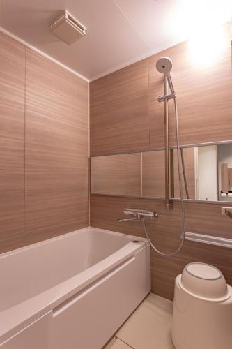 a bathroom with a bath tub and a toilet at Kissuien Stay&Food in Kyotango
