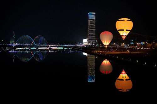 two hot air balloons flying over the water at night at Hotel Onoma Daejeon, Autograph Collection in Daejeon