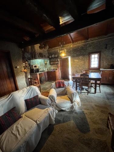 a living room with couches and a dining room with a table at Abrigo das Penhas in Manteigas