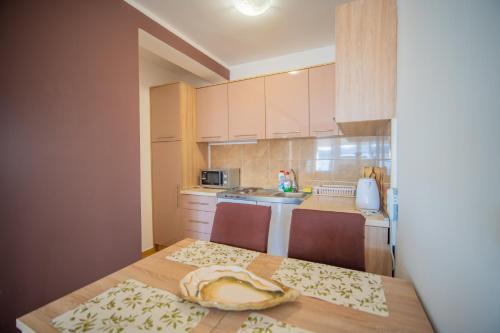 a kitchen with a table with two chairs and a sink at Apartman Centar in Tivat
