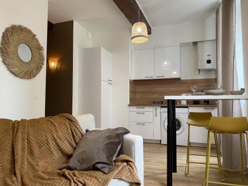 un salon avec une table et une cuisine dans l'établissement Le Pacha, en hypercentre, à Vienne