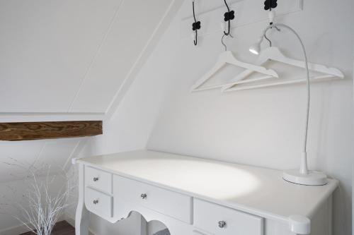 a white dresser with a lamp on top of it at Boerderij de Borgh in Westerbork