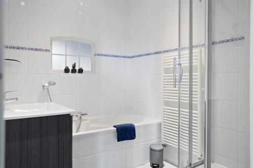 a white bathroom with a tub and a sink at Boerderij de Borgh in Westerbork