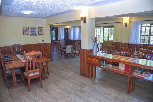 a dining room with wooden tables and chairs at Sangare Gardens- Book Now Enjoy Free Farm Tour in Mweiga