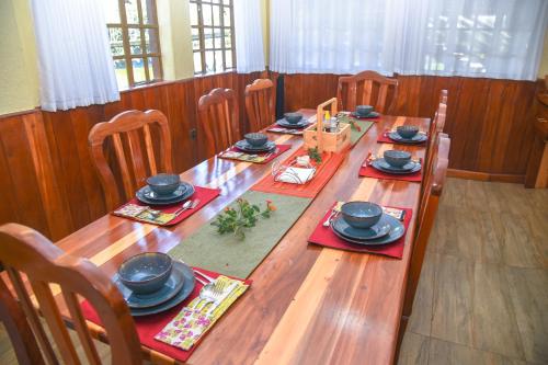 a long wooden table with chairs and hats on it at Sangare Gardens- Book Now Enjoy Free Farm Tour in Mweiga
