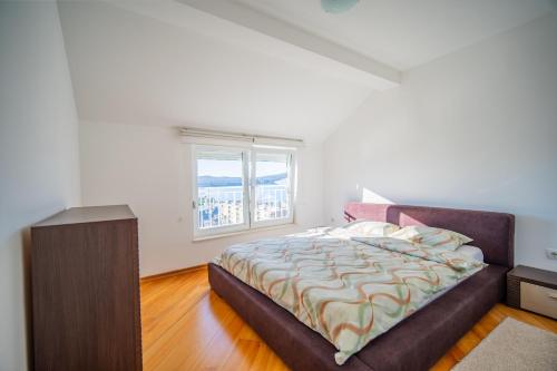 a bedroom with a large bed and a window at Apartman Centar in Tivat