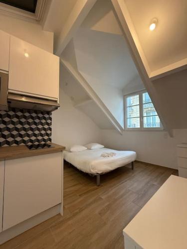 Cette chambre mansardée comprend un lit et une fenêtre. dans l'établissement Studio in the 16th, à Paris