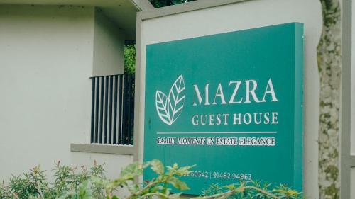 a sign for a guest house on the side of a building at Mazra Retreat, Coorg Kushālnagar in Kushālnagar