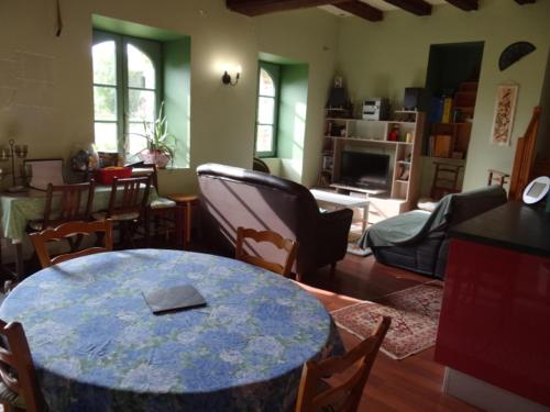 une chambre avec une table et des chaises ainsi qu'un salon dans l'établissement Logis de la Provosterie - CYCLAMEN, à Ahuillé
