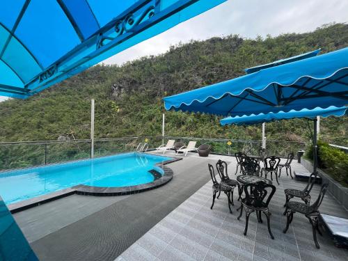 a patio with tables and chairs next to a swimming pool at Cannon Fort - The Viewpoint Hotel in Cat Ba