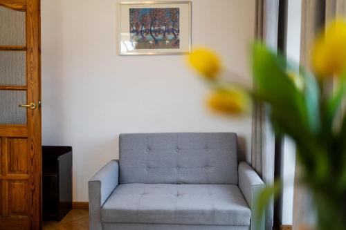 a blue couch in a living room with a painting at Hotel Europa in Polanica-Zdrój