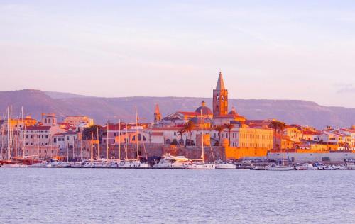 a view of a city with boats in the water at Glamping at Sardinia in Alghero