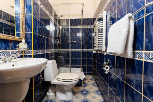 niebieska kafelkowa łazienka z toaletą i umywalką w obiekcie Hotel Europa w Polanicy Zdroju