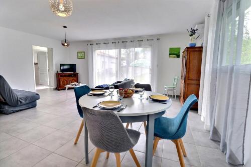 a dining room and living room with a table and chairs at Maison chaleureuse Sud Ardèche in Pradons