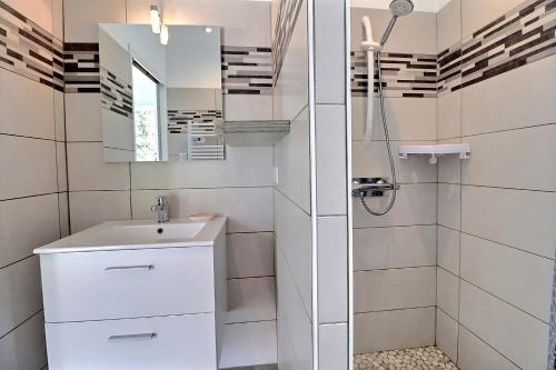 a white bathroom with a sink and a mirror at Maison chaleureuse Sud Ardèche in Pradons