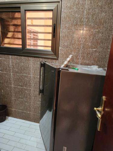 a bathroom with a refrigerator and a window at Appartements meublés village CAN in Bamako