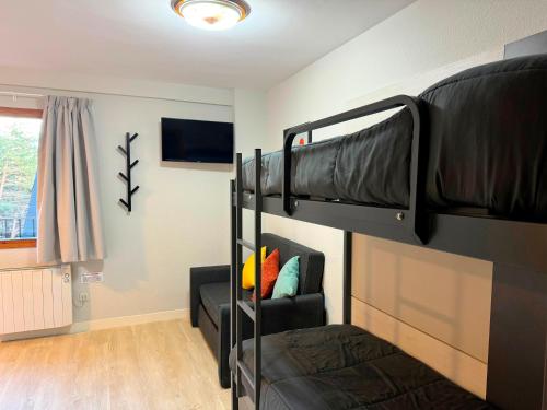 a dorm room with two bunk beds and a couch at Apartamentos Midi 3000 in Formigal