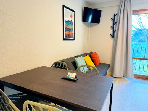 a living room with a table and a couch at Apartamentos Midi 3000 in Formigal