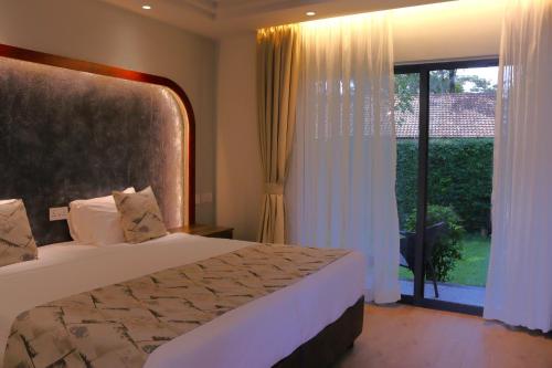 a bedroom with a bed and a large window at Sportsview Hotel Kasarani in Nairobi