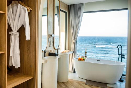 a bathroom with a tub and two sinks and the ocean at Serō Boutique Hotel in Cù Lao Thu