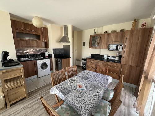 une cuisine avec une table et une salle à manger dans l'établissement Les Dunes, à Saint-Gilles-Croix-de-Vie