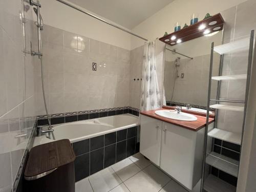 une salle de bain avec une baignoire et un lavabo dans l'établissement Les Dunes, à Saint-Gilles-Croix-de-Vie