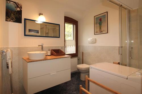 ein Badezimmer mit Waschbecken, Toilette und Dusche in der Unterkunft Casa Bella in Polpenazze del Garda