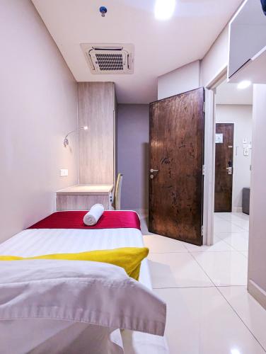 a bedroom with a bed and a wooden door at Le Quadri Kuala Lumpur By UCSI Hotels in Kuala Lumpur
