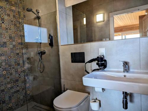 a bathroom with a sink and a toilet and a shower at Stranda in Giżycko