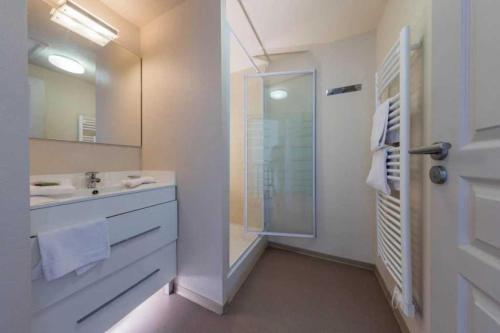 une salle de bain blanche avec une douche et un lavabo dans l'établissement Camping 3 étoiles - Piscine - eega0d, à Saint-Christol