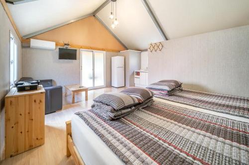 two twin beds in a room with a tv at Pocheon KidsGlampingGEO in Pocheon
