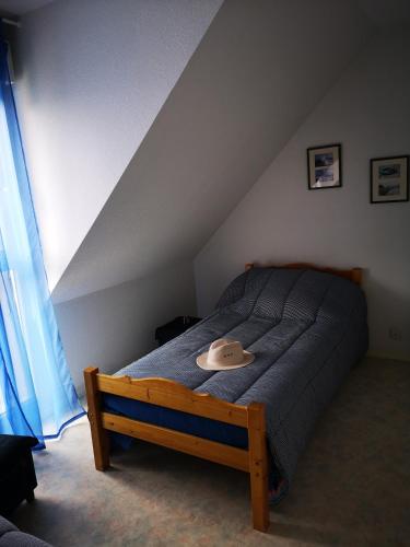 une chambre avec un lit avec un chapeau dessus dans l'établissement Maison Ker Pica, au Croisic
